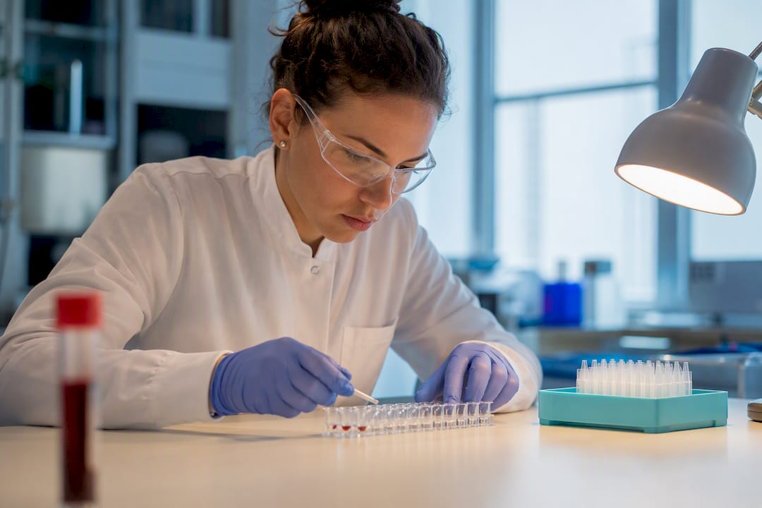 Technologist inspecting hepatitis B assay wells