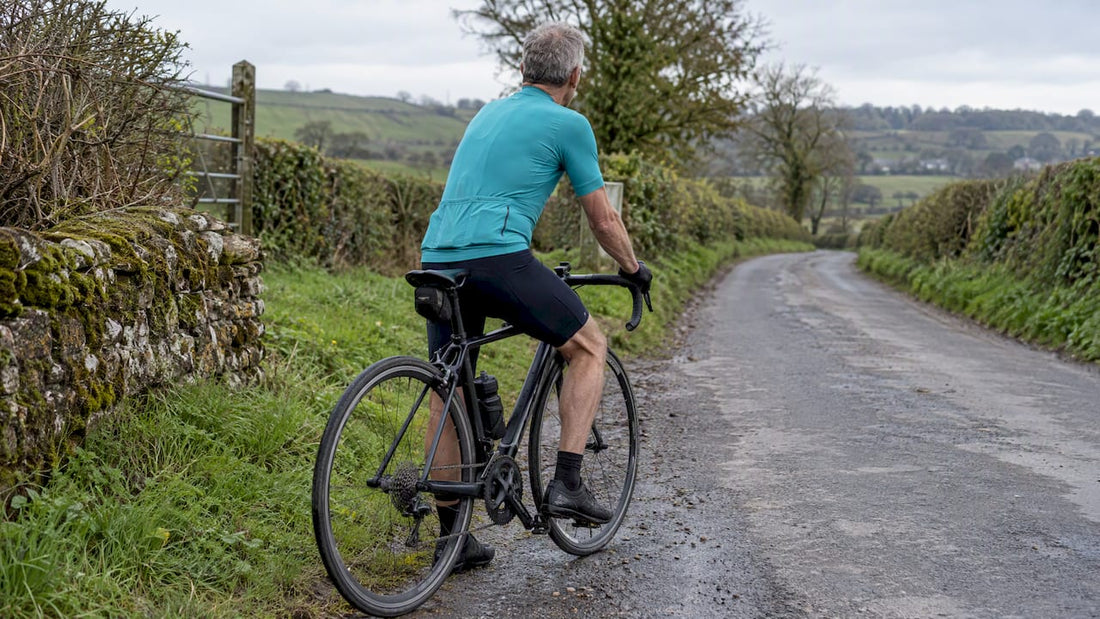 Older cyclist stopping on a country road