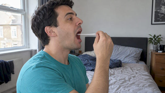 Adult taking a throat swab at home