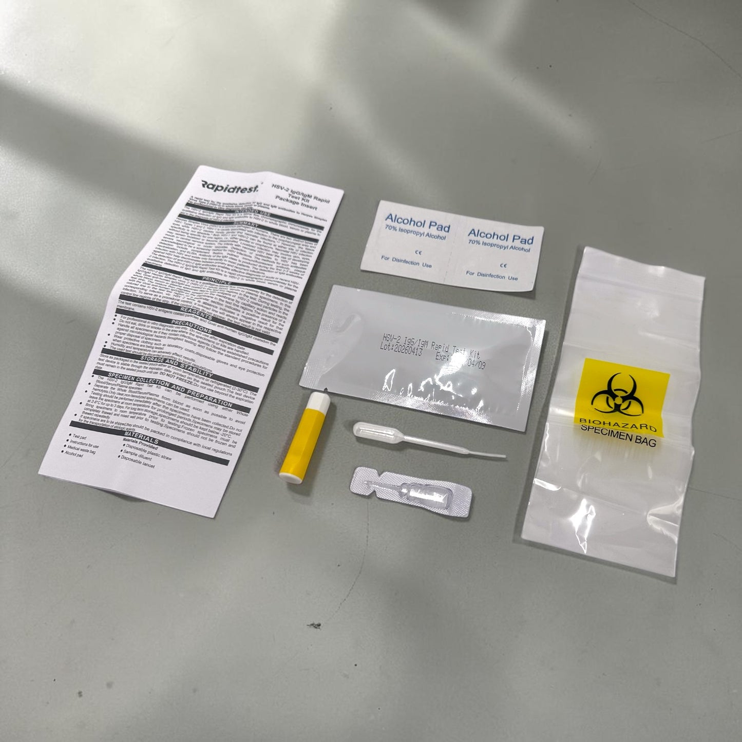 Genital herpes self test package items included on grey background. rapidtest.co