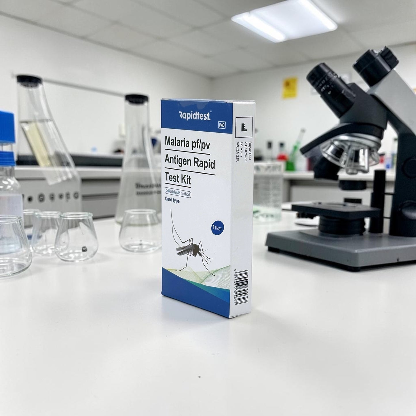 Malaria test kit box on a laboratory counter with a microscope in the background - rapidtest.co