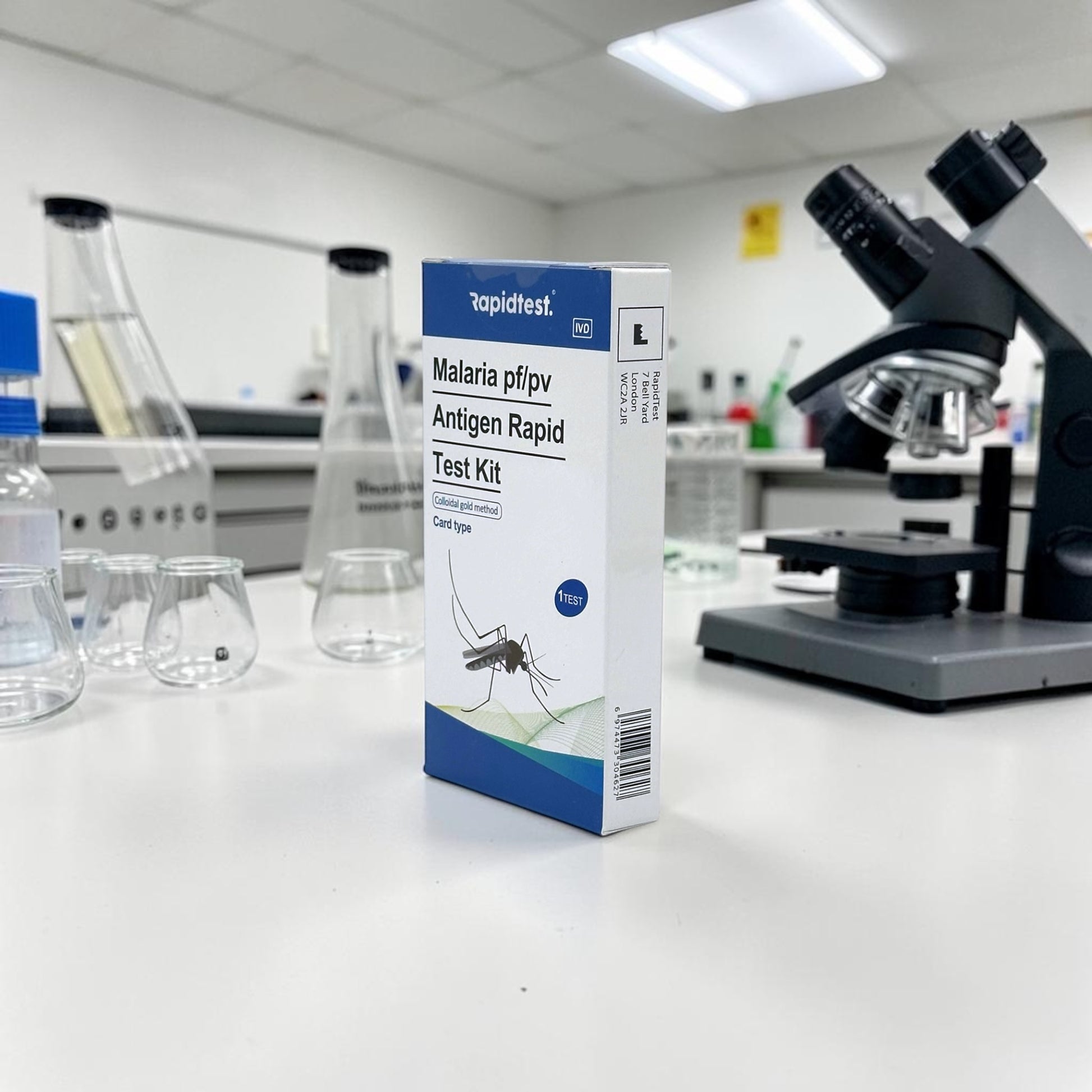 Malaria test kit box on a laboratory counter with a microscope in the background - rapidtest.co